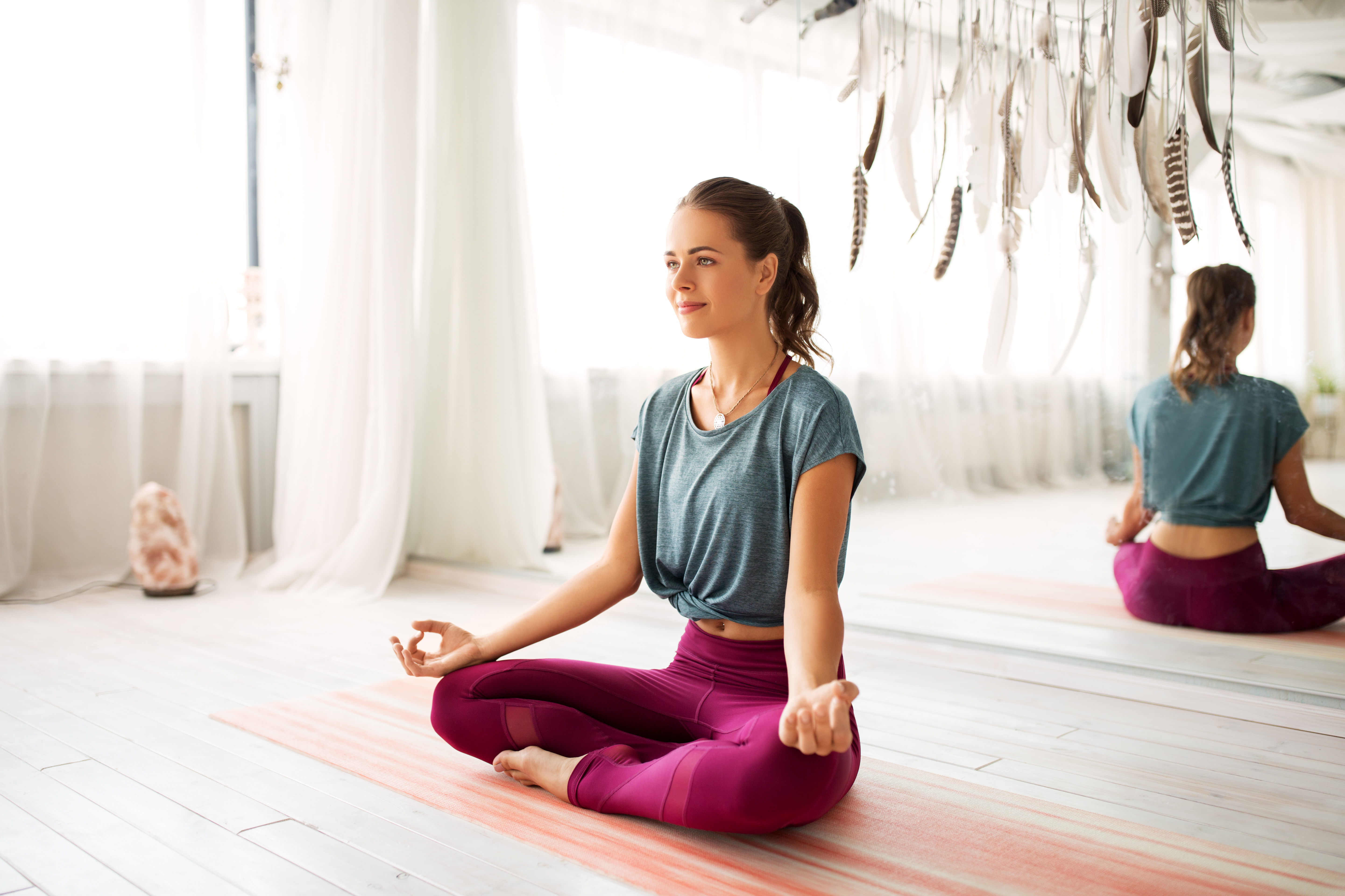 wanita bermeditasi dalam pose lotus di studio yoga